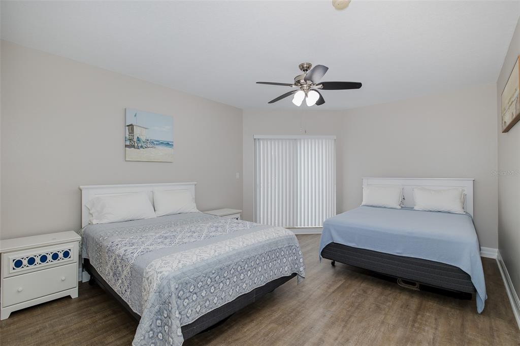 4516 Seagull Drive, Unit 411 New Port Richey, FL 34652 - Photo 25 of 47 a bedroom with a bed chandelier and a window