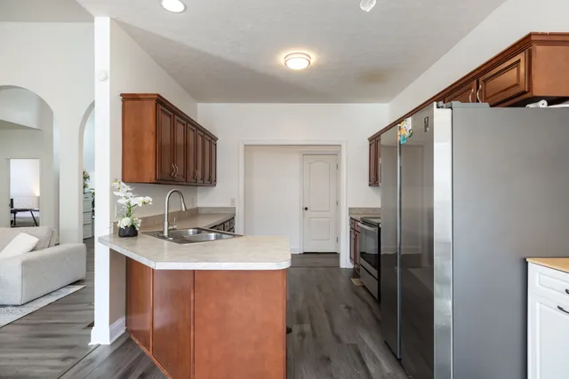 a kitchen with stainless steel appliances granite countertop a refrigerator a sink and a stove