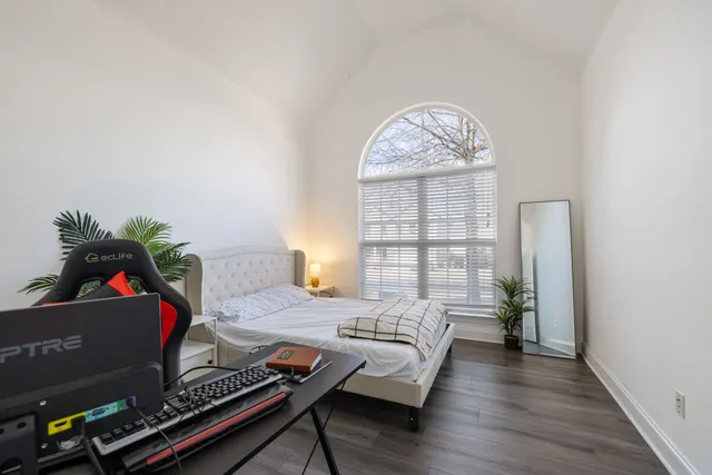 an empty room with wooden floor and window