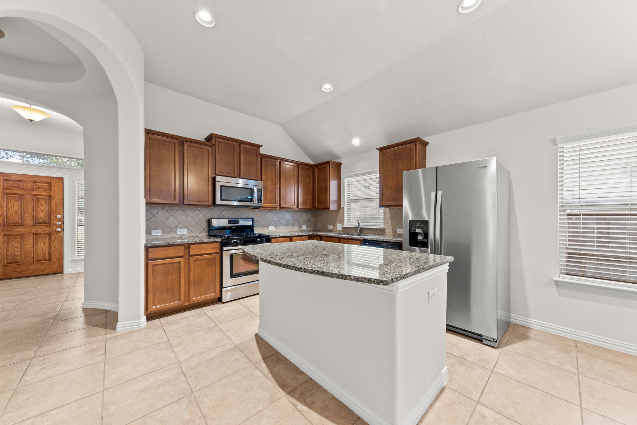 411 Tascate Street Georgetown, TX 78628 - Photo 13 of 41 Culinary creations come to life in this kitchen, featuring an island with granite counters and stainless steel appliances.