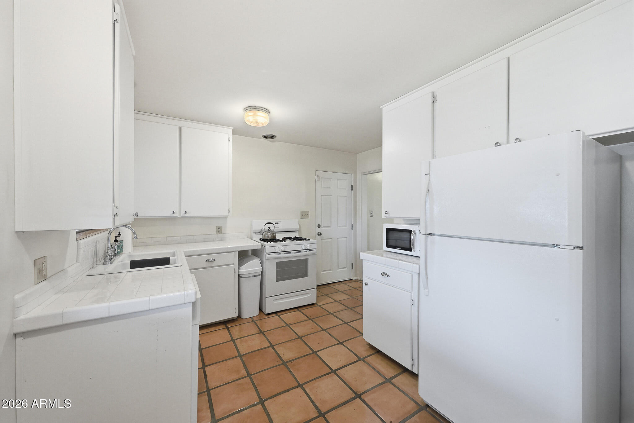 2215 West Earll Drive Phoenix, AZ 85015 - Photo 11 of 55 a kitchen with white cabinets and white appliances