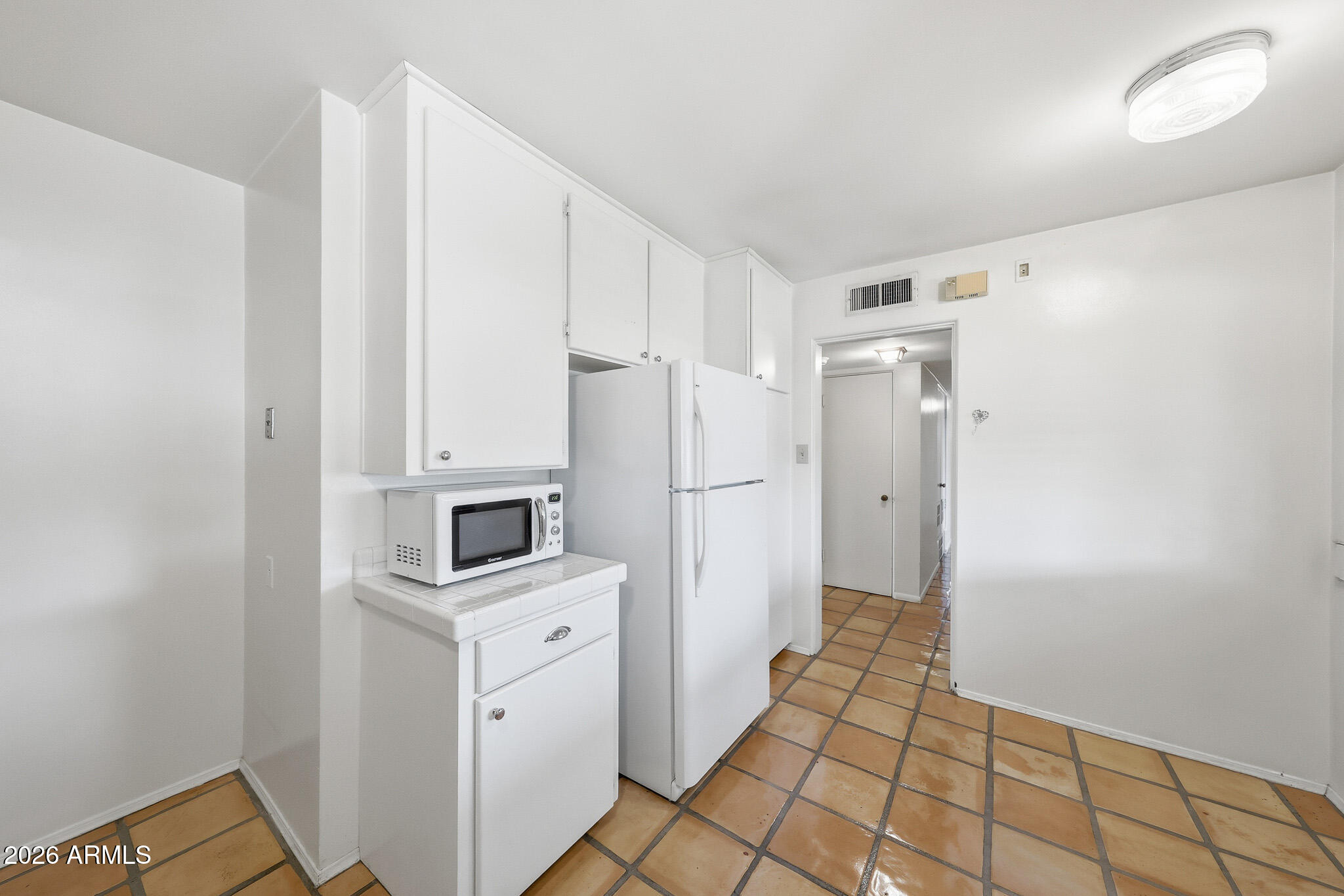 2215 West Earll Drive Phoenix, AZ 85015 - Photo 14 of 55 a kitchen with white cabinets and refrigerator