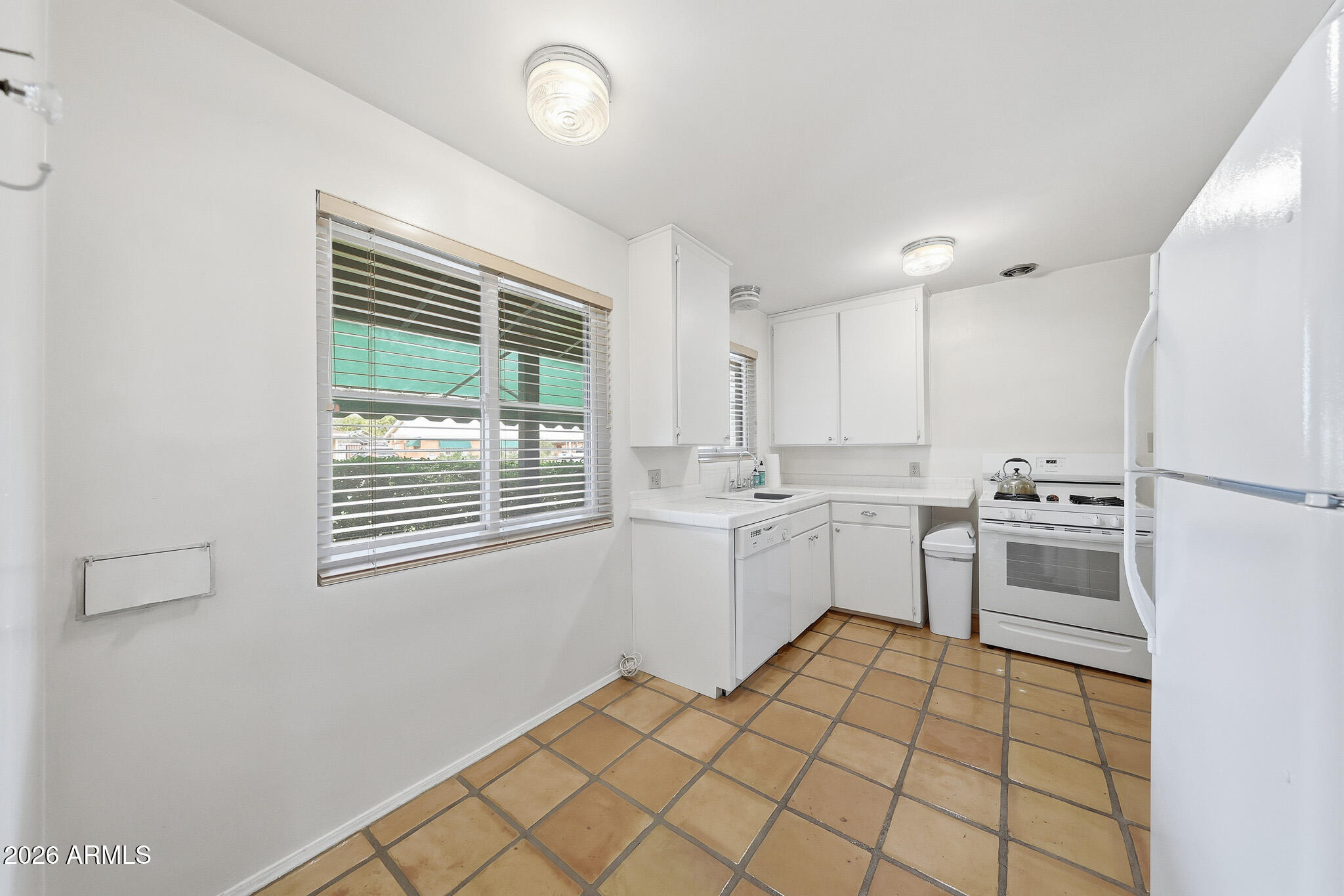 2215 West Earll Drive Phoenix, AZ 85015 - Photo 10 of 55 a kitchen with white cabinets and white appliances