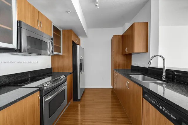 a kitchen with stainless steel appliances a stove microwave and sink