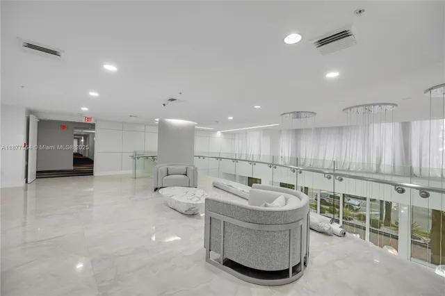 a large living room with stainless steel appliances lots of white furniture