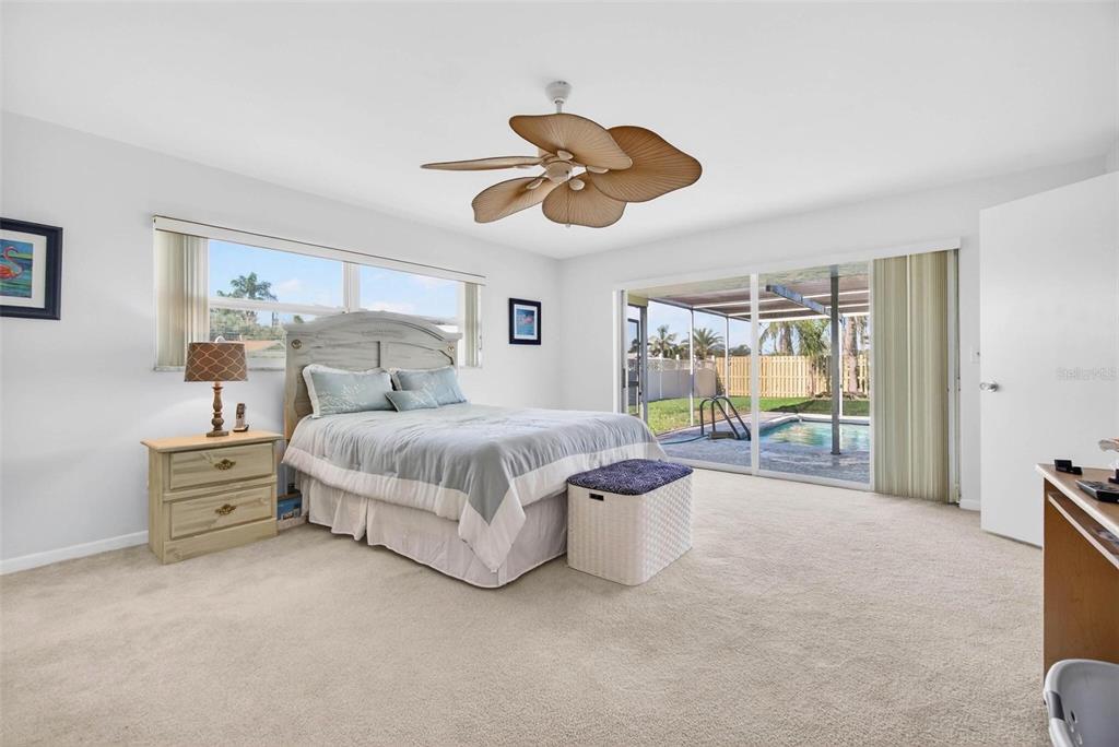 10100 Commodore Drive Seminole, FL 33776 - Photo 13 of 43 a bedroom with a bed and a chandelier