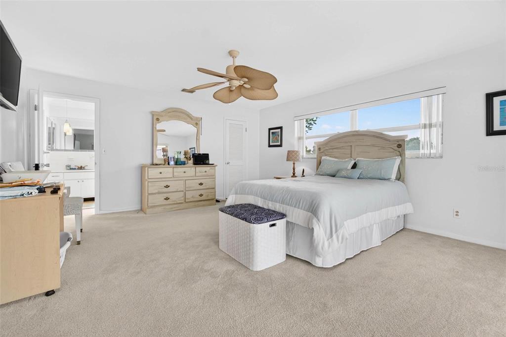 10100 Commodore Drive Seminole, FL 33776 - Photo 14 of 43 a bedroom with a bed and ceiling fan
