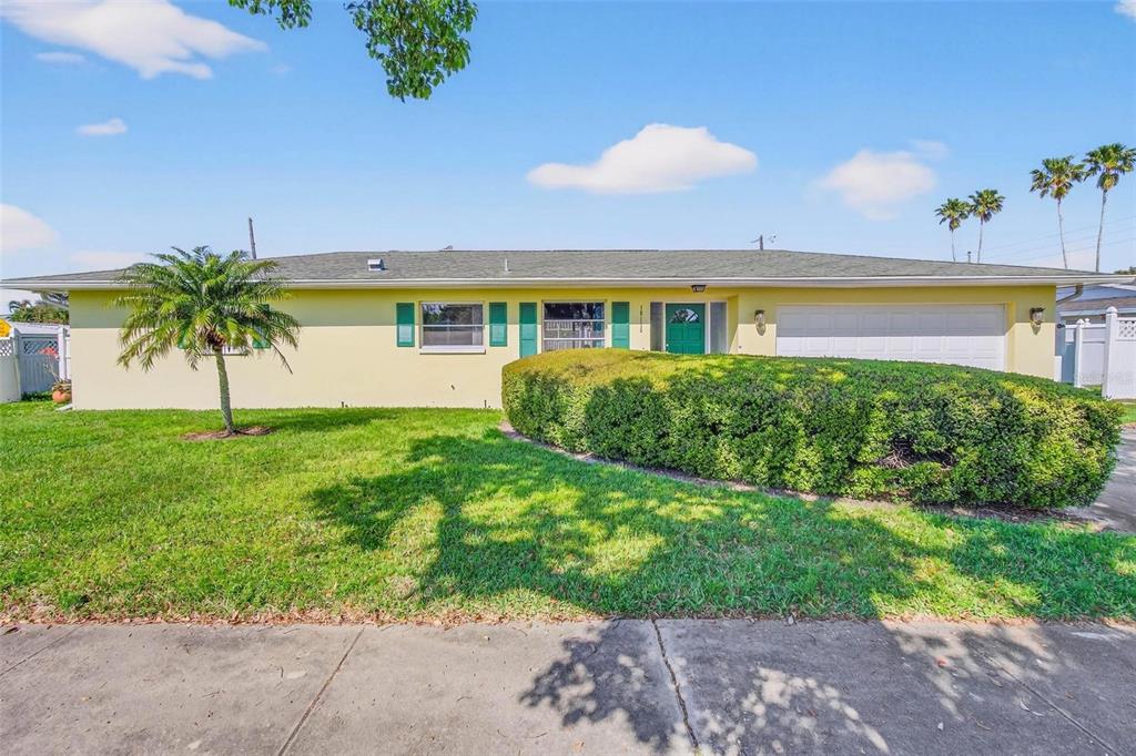 10100 Commodore Drive Seminole, FL 33776 - Photo 2 of 43 a front view of a house with a garden