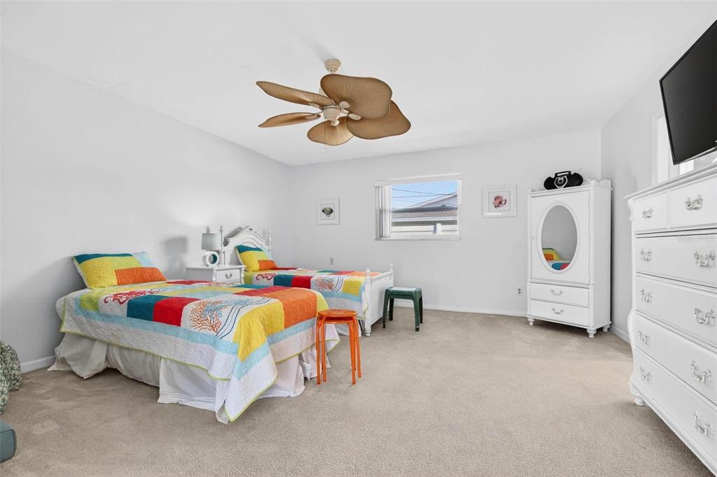 10100 Commodore Drive Seminole, FL 33776 - Photo 21 of 43 a bedroom with a bed and a chandelier