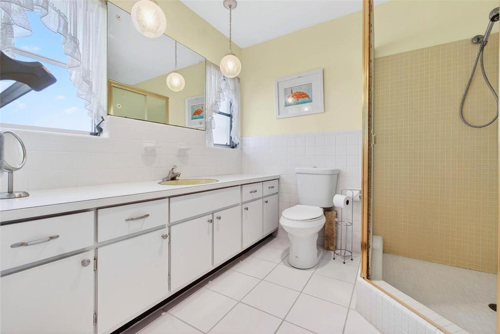 10100 Commodore Drive Seminole, FL 33776 - Photo 24 of 43 a spacious bathroom with a toilet sink and mirror