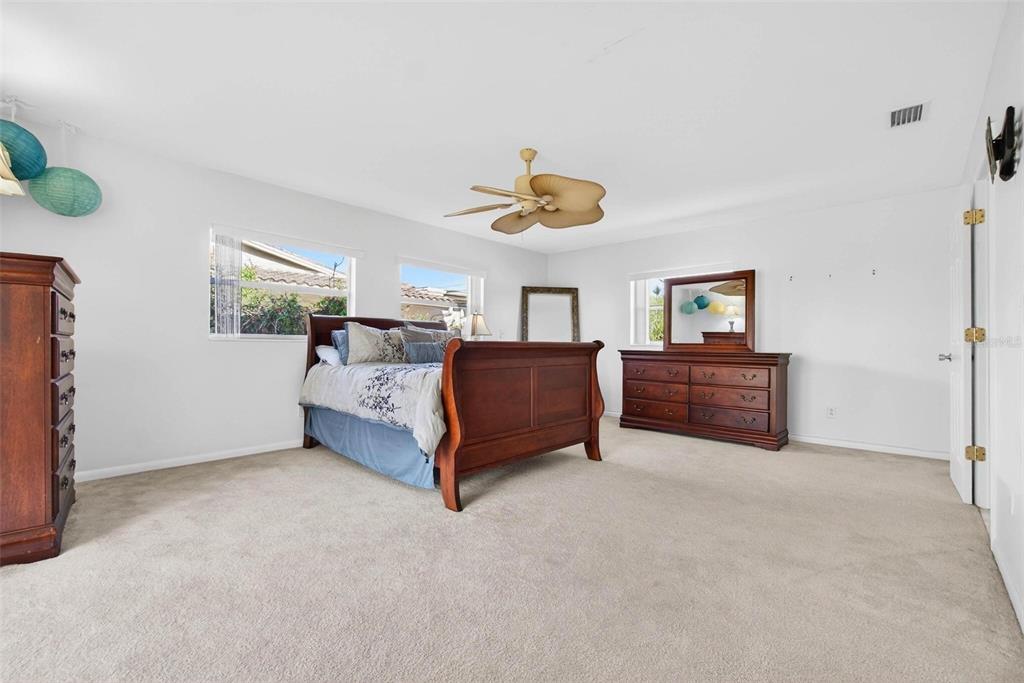 10100 Commodore Drive Seminole, FL 33776 - Photo 27 of 43 a spacious bedroom with a bed dresser and a window