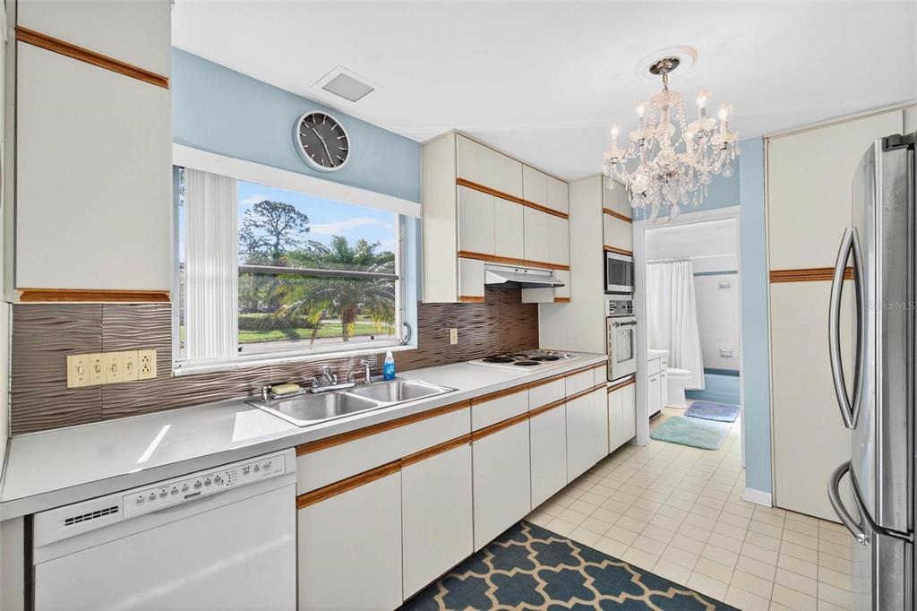 10100 Commodore Drive Seminole, FL 33776 - Photo 10 of 43 a large white kitchen with a sink and large window