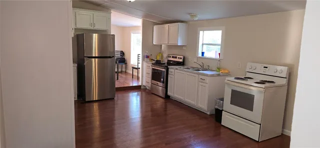 a kitchen with a refrigerator stove and wooden floor