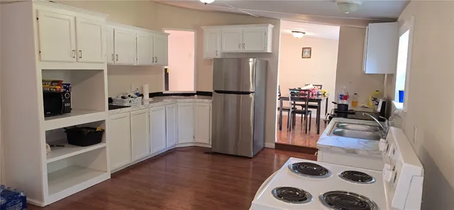 a kitchen with a refrigerator and a stove top oven