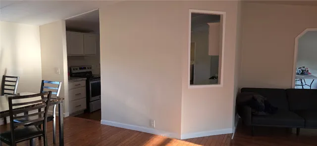 a view of a hallway with wooden floor and closet