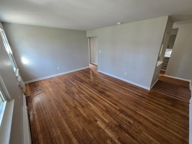a view of an empty room with wooden floor