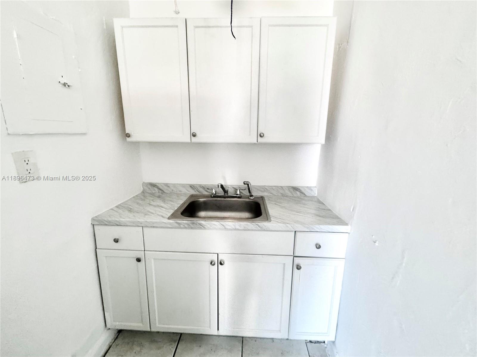 825 Northwest 9th Street, Unit 825 Hallandale Beach, FL 33009 - Photo 7 of 18 a kitchen with a sink cabinets and a microwave