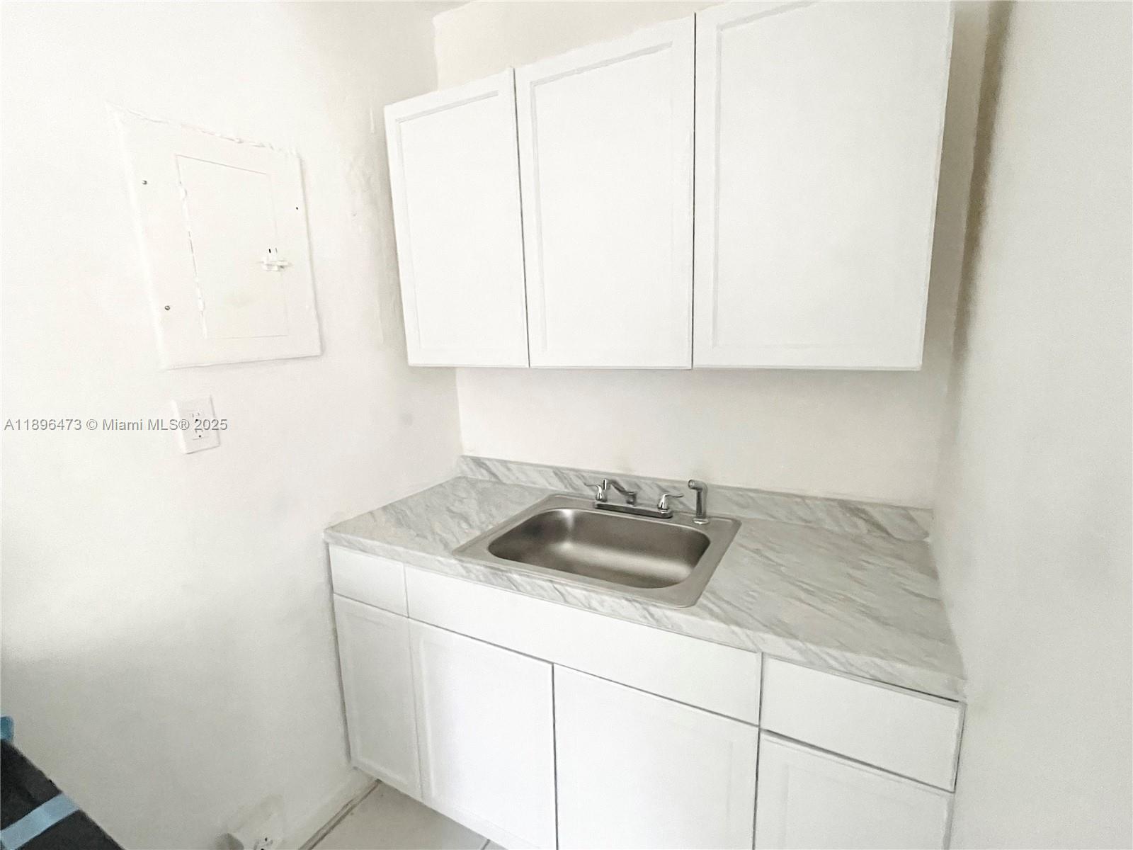 825 Northwest 9th Street, Unit 825 Hallandale Beach, FL 33009 - Photo 8 of 18 a kitchen with a sink and cabinets