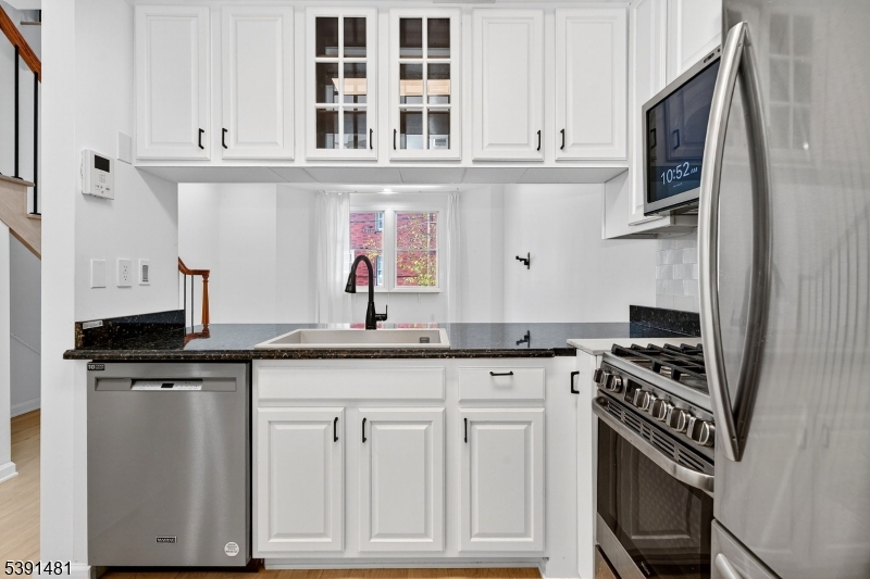 159 Palisade Avenue, Unit 2R Jersey City, NJ 07306 - Photo 11 of 26 a kitchen with granite countertop a stove sink and cabinets