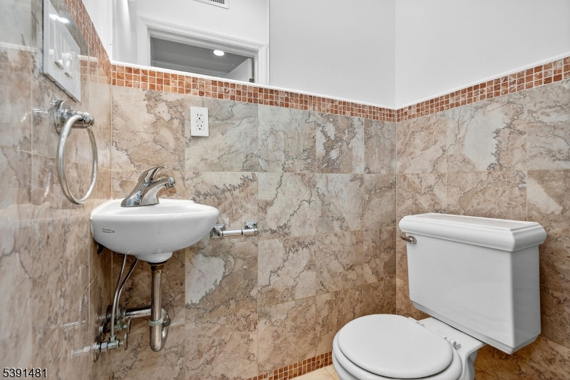 159 Palisade Avenue, Unit 2R Jersey City, NJ 07306 - Photo 12 of 26 a bathroom with a toilet sink and mirror