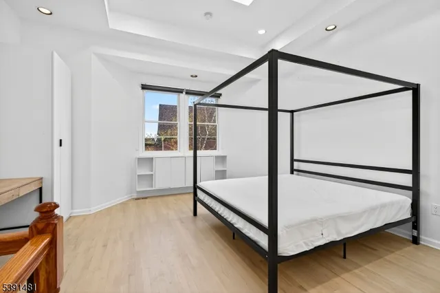 a spacious bedroom with a bed and a dresser with mirror