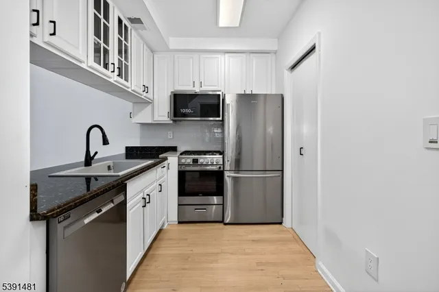 a kitchen with stainless steel appliances a stove sink and refrigerator
