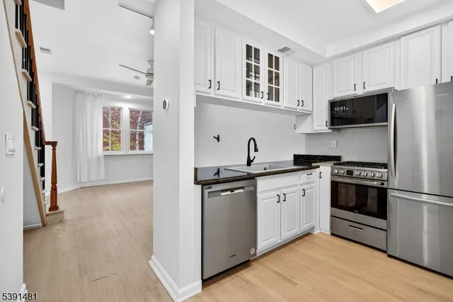 a kitchen with granite countertop a stove sink and cabinets