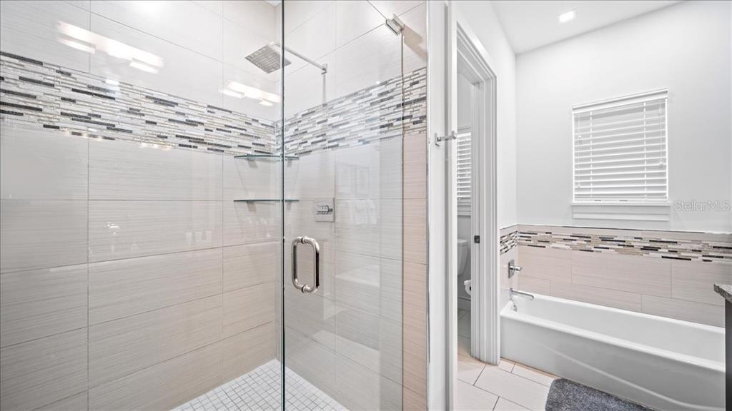 331 Muirfield Loop Reunion, FL 34747 - Photo 33 of 100 a bathroom with a shower and a chandelier