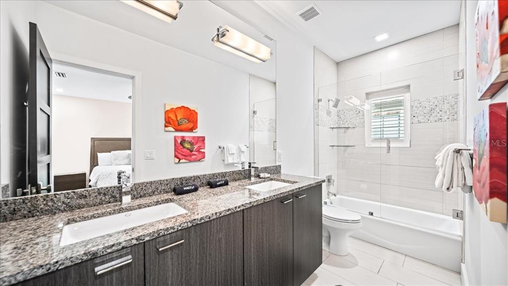 331 Muirfield Loop Reunion, FL 34747 - Photo 54 of 100 a bathroom with a granite countertop sink mirror vanity and bathtub