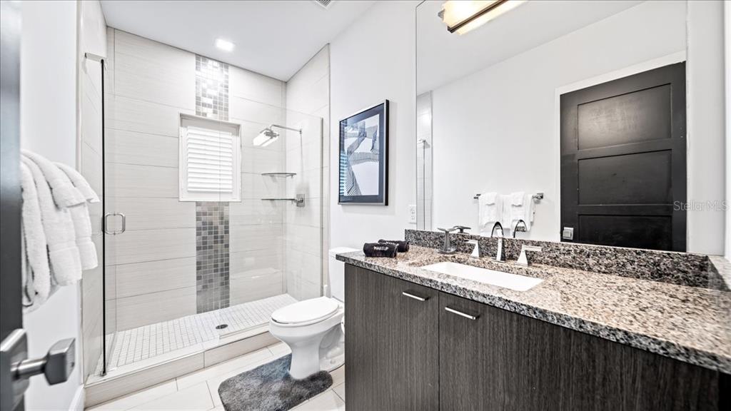 331 Muirfield Loop Reunion, FL 34747 - Photo 59 of 100 a bathroom with a granite countertop sink toilet and shower