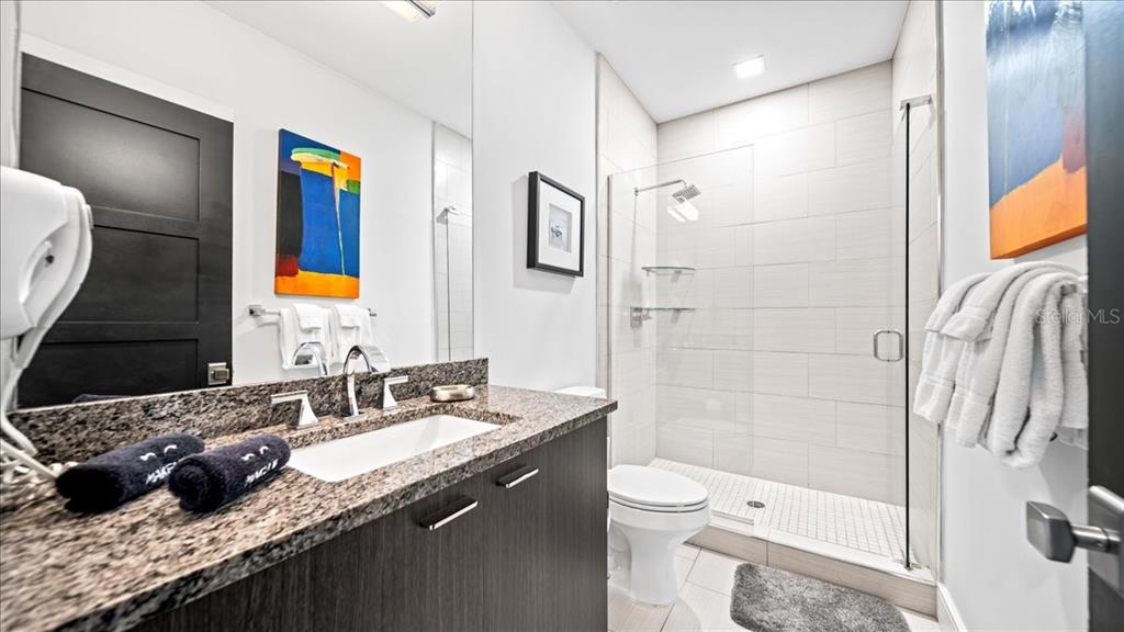 331 Muirfield Loop Reunion, FL 34747 - Photo 61 of 100 a bathroom with a granite countertop sink toilet and shower