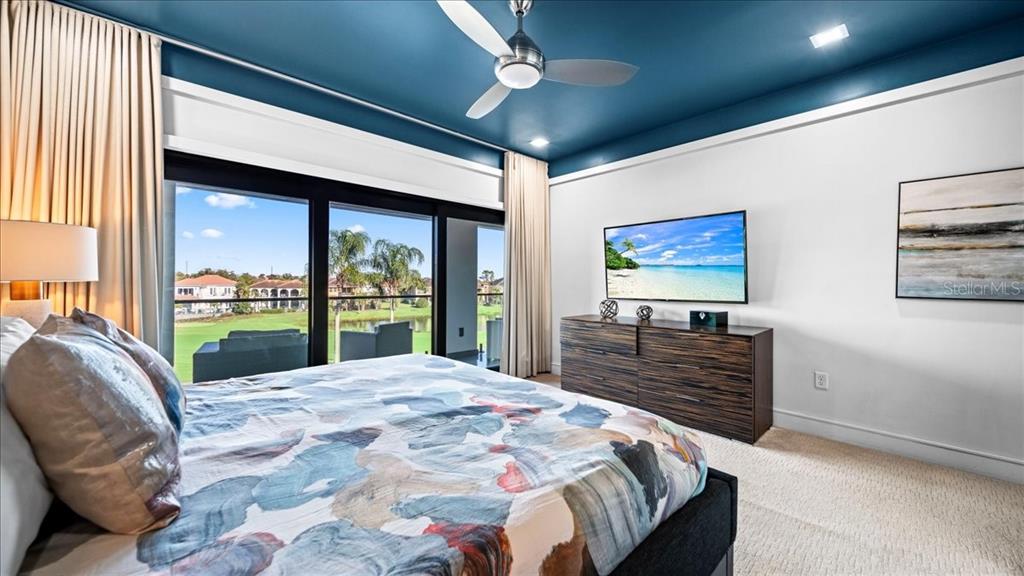 331 Muirfield Loop Reunion, FL 34747 - Photo 63 of 100 a bedroom with a large bed and a flat screen tv