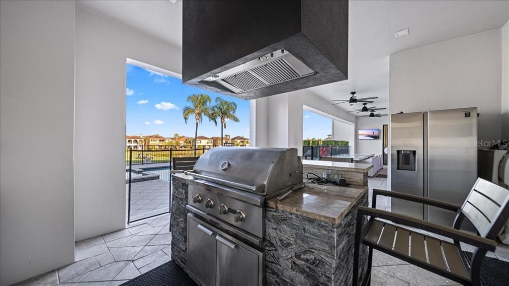331 Muirfield Loop Reunion, FL 34747 - Photo 98 of 100 a kitchen with stainless steel appliances granite countertop a stove a refrigerator and a view of living room