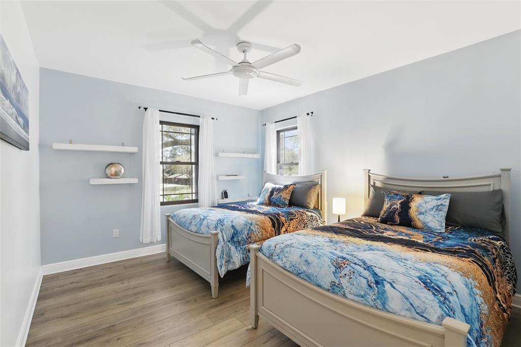 106 Victoria Street Merritt Island, FL 32952 - Photo 29 of 51 a bedroom with two beds and a chandelier