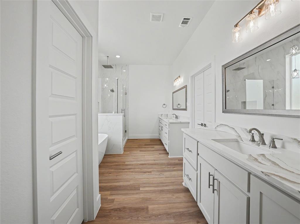 328 Slimp Bluff Azle, TX 76020 - Photo 15 of 30 Spacious bathroom featuring wood-finish flooring, a freestanding tub, and a glass-enclosed shower with a rainfall showerhead