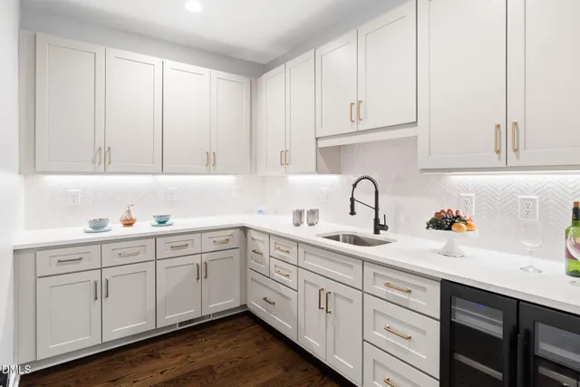 a kitchen with kitchen island a stove a sink a dining table and chairs with wooden floor