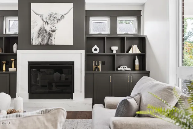 a living room with furniture a fireplace and a chandelier