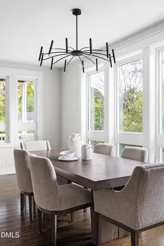 a dining room with furniture window and wooden floor