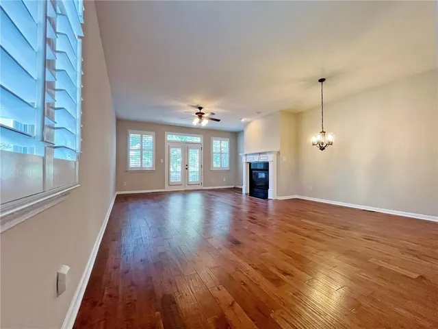 a view of a room with wooden floor and ceiling fan
