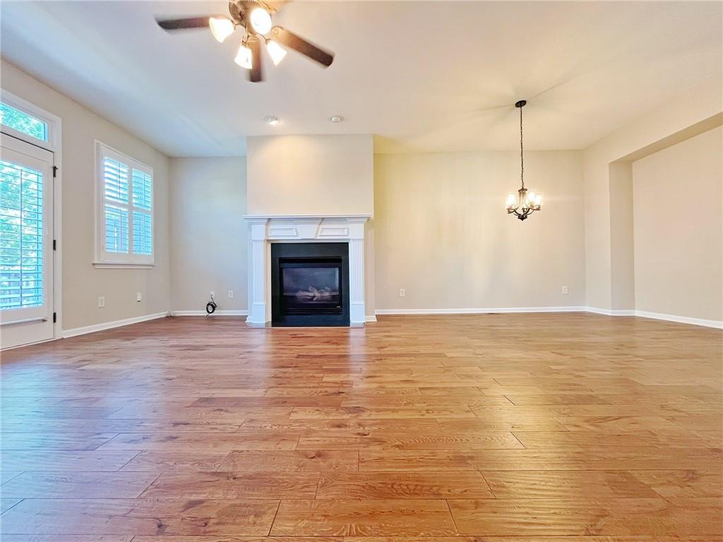 525 Grove Field Court Northwest Suwanee, GA 30024 - Photo 16 of 57 a view of empty room with wooden floor and fireplace