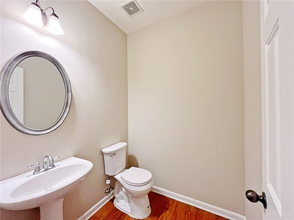 525 Grove Field Court Northwest Suwanee, GA 30024 - Photo 25 of 57 a bathroom with a toilet a sink and mirror