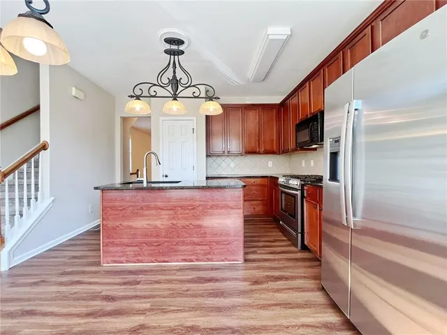 an empty room with chandelier fan and windows