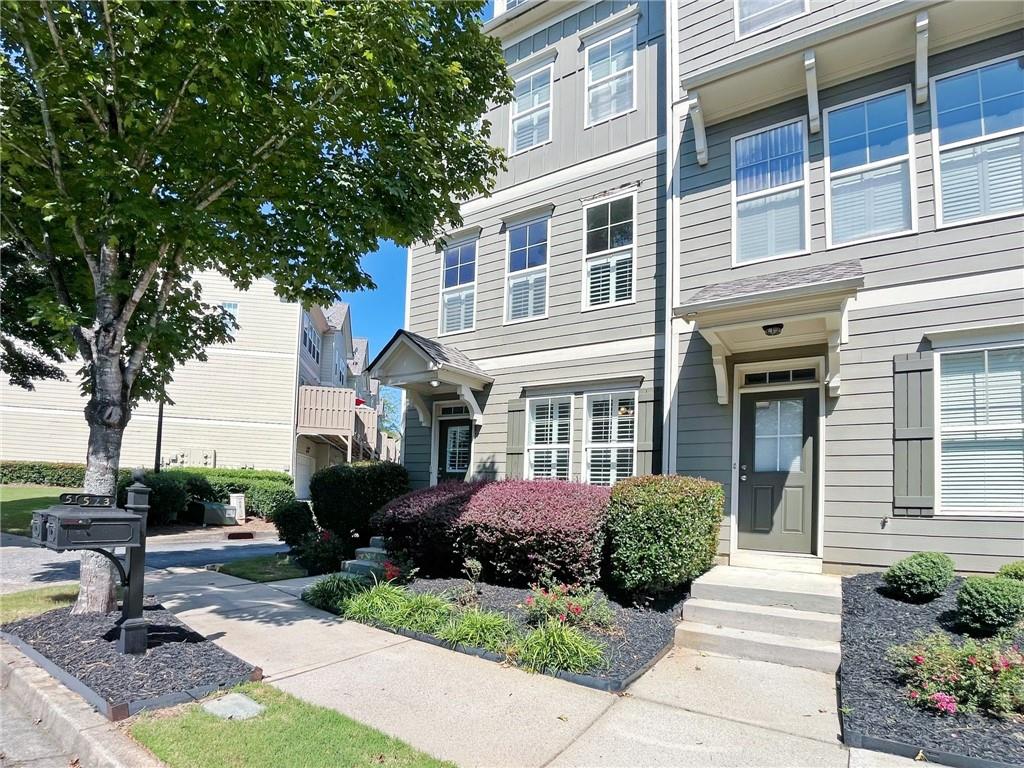 525 Grove Field Court Northwest Suwanee, GA 30024 - Photo 3 of 57 a front view of a house with garden and trees