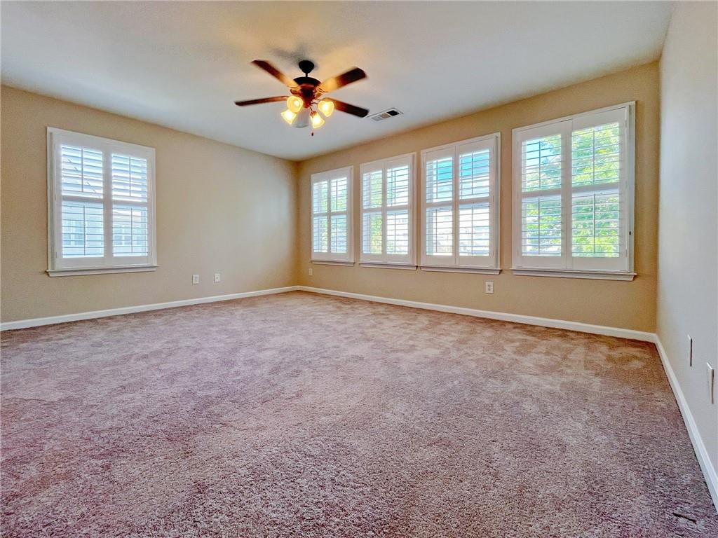 525 Grove Field Court Northwest Suwanee, GA 30024 - Photo 34 of 57 an empty room with chandelier fan and windows