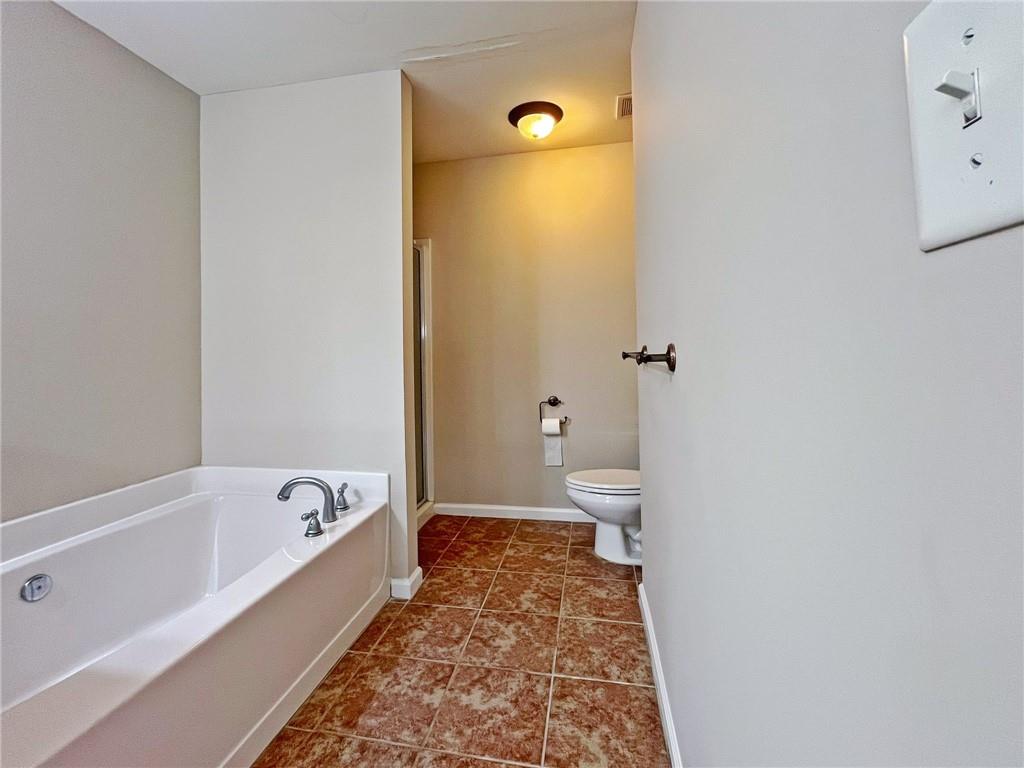 525 Grove Field Court Northwest Suwanee, GA 30024 - Photo 39 of 57 a bathroom with a bathtub and toilet