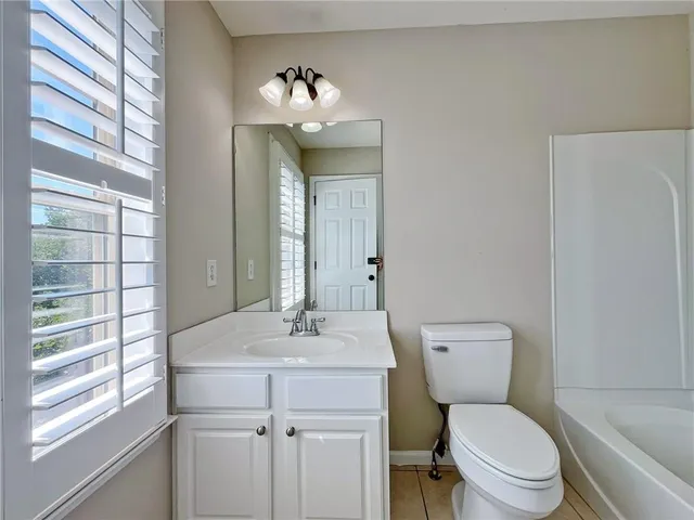a view of swimming pool with lawn chairs and plants