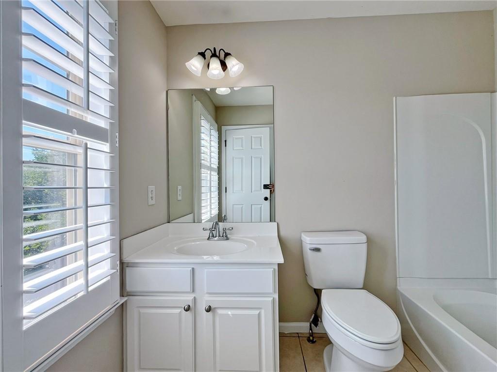 525 Grove Field Court Northwest Suwanee, GA 30024 - Photo 47 of 57 a bathroom with a toilet a sink and mirror
