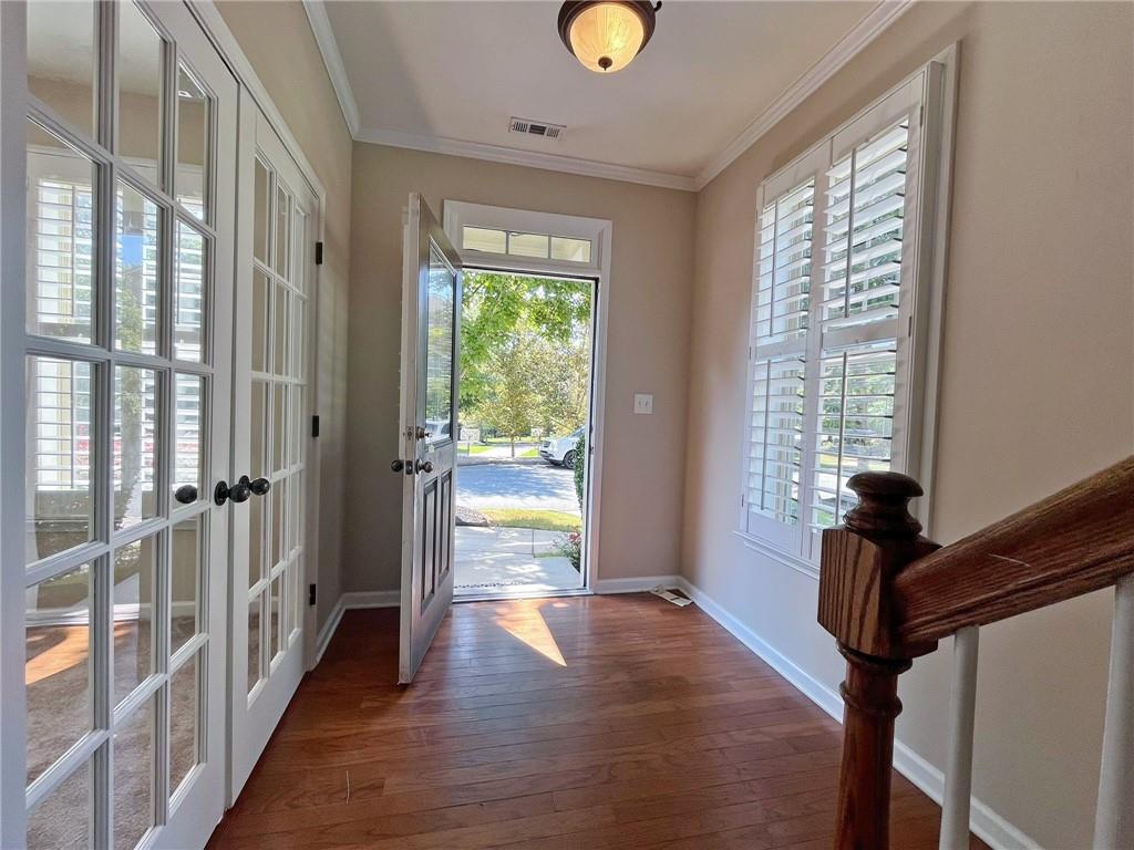 525 Grove Field Court Northwest Suwanee, GA 30024 - Photo 6 of 57 a view of a hallway with wooden floor and windows