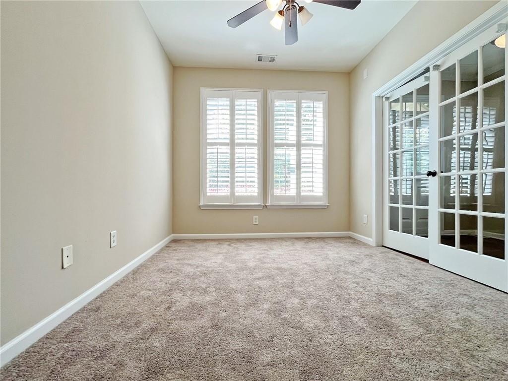 525 Grove Field Court Northwest Suwanee, GA 30024 - Photo 9 of 57 an empty room with windows and chandelier fan