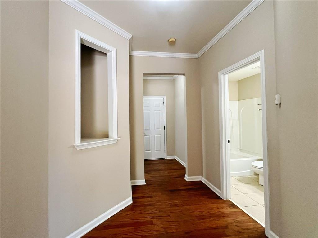 525 Grove Field Court Northwest Suwanee, GA 30024 - Photo 10 of 57 an empty room with wooden floor and a bathroom